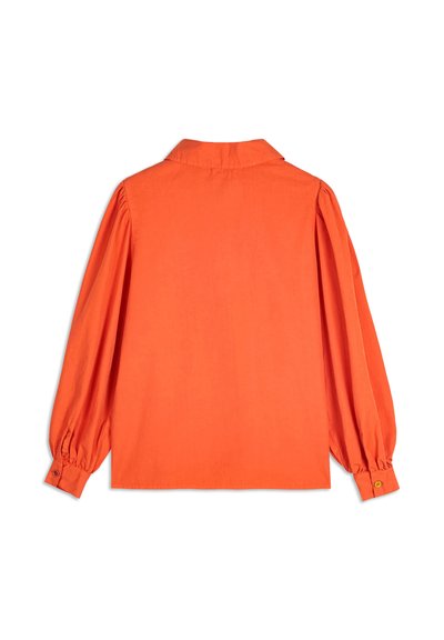 Oranssikauluksinen paita pitkillä puff-hihnoilla, napilla varustetuilla hihoilla, sileällä pinnalla ja istuvalla leikkauksella. Takapuolelta näkyy siistit viivat ja saumuriedet.