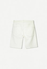 Fehér denim sort egyenes szabással, két hátsó rávarrt zsebbel és lapos derékkal. Sima textúra, látható minták nélkül.