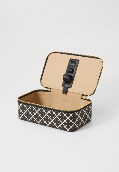 Black and cream patterned zippered case with a beige interior, featuring a black strap closure and gold zipper. Open and unfilled.