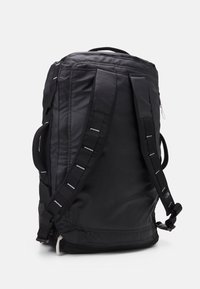 Mustan reppu, joka on valmistettu kestävästä kankaasta. Sen mukana tulee pehmustetut olkaimet, ylhäältä löytyvä kantohandle ja vetoketjullinen pääosasto minimalistisella muotoilulla.