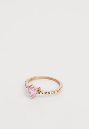 Ring aus Roségold mit einem herzförmigen pinken Stein und einer Reihe klarer, simulierten Diamanten entlang des Rings. Glatte, polierte Oberfläche.