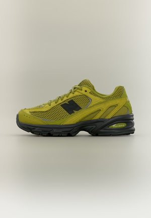 Scarpa da ginnastica New Balance verde oliva e nera con tomaia in mesh, sovrapposizioni in suede e suola ammortizzata con tecnologia ABZORB.