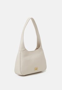 Beige läderaxelväska med en bred rem och en liten rektangulär guldsymbol med texten "Love Moschino" på framsidan.