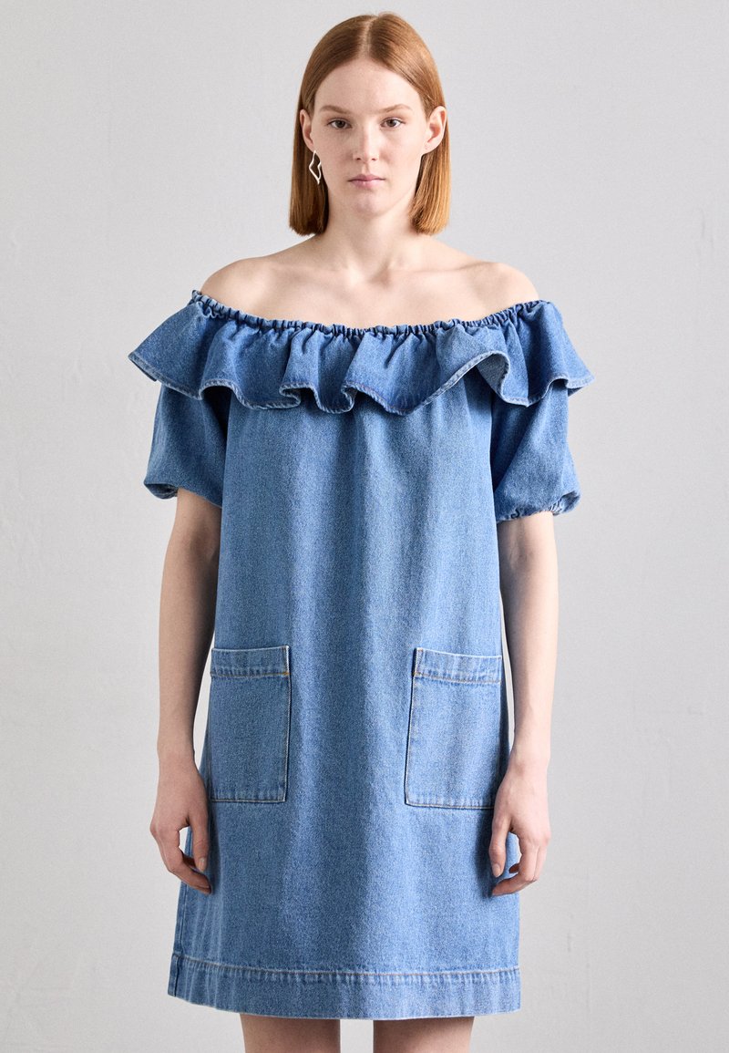Denim haljina bez ramena s volanima oko vrata, kratkim rukavima, dva prednja džepa i ležernim krojem u svijetloplavoj boji.
