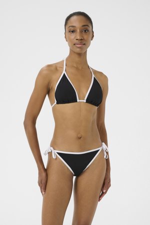Bikini nero con coppe triangolari e lacci regolabili. Contrasto con rifiniture bianche, con una texture liscia e un design minimalista.