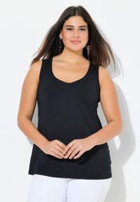 Camiseta sin mangas negra con escote redondeado y corte relajado, hecha de una tela suave. Presenta un sutil detalle de costura en el escote.