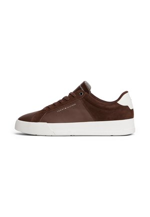 Brązowy niski skórzany sneaker z białą podeszwą i pętelką na pięcie, wiązany, z logo „Tommy Hilfiger” po boku i na języku.