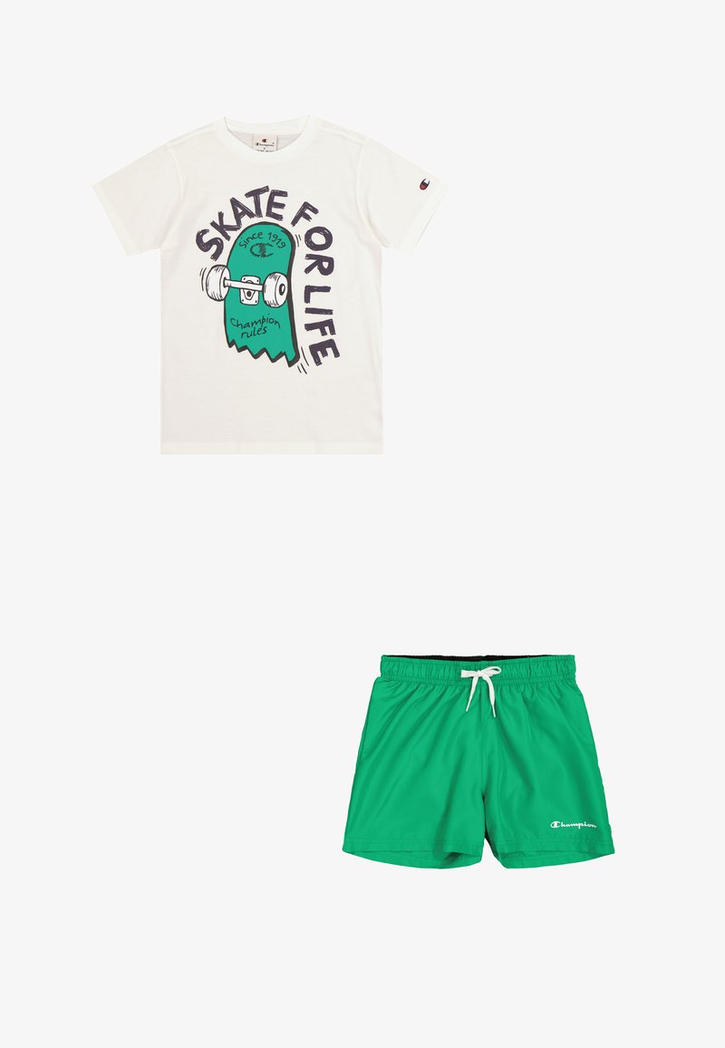 Camiseta blanca con un gráfico de monopatín en verde y negro y el texto "SKATE FOR LIFE". Bañador verde con cintura elástica y cordón.