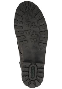 Suola in gomma nera con scanalature profonde e motivi in rilievo. Presenta un design arrotondato con il logo "remonte" vicino all'arco.
