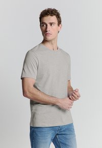 Grijze t-shirt met korte mouwen, gemaakt van katoen, met een ronde hals, een relaxte pasvorm en een gladde textuur. Draagdit met een blauwe denim jeans.