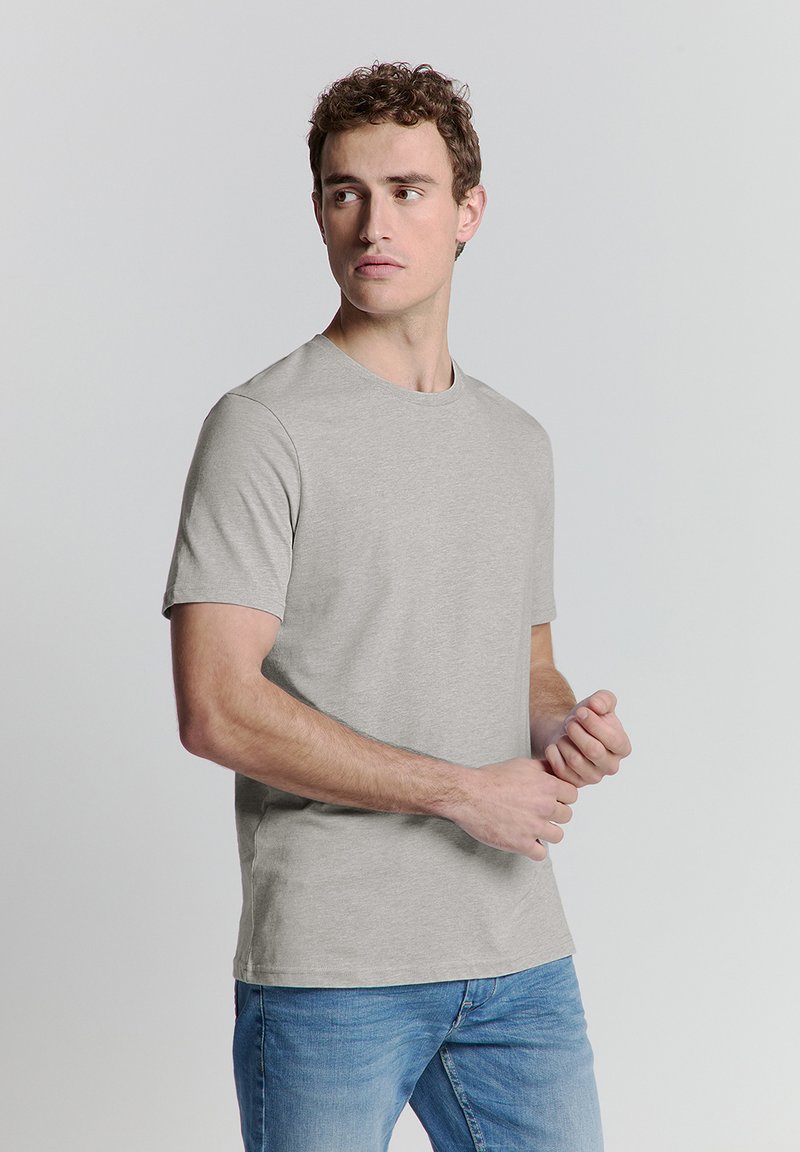 Grijze t-shirt met korte mouwen, gemaakt van katoen, met een ronde hals, een relaxte pasvorm en een gladde textuur. Draagdit met een blauwe denim jeans.