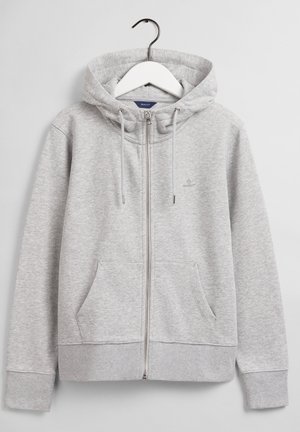 Hellgrauer Hoodie mit Reißverschluss, Kordelzugkapuze und Fronttaschen, aufgehängt an einem weißen Kleiderbügel vor neutralem Hintergrund.