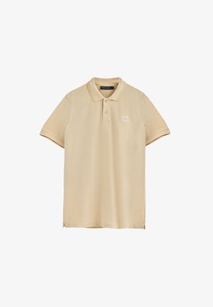 Beżowa koszulka polo wykonana z miękkiej bawełny, z klasycznym kołnierzykiem, krótkimi rękawami, trzema guzikami i subtelnym logo marki na piersi.