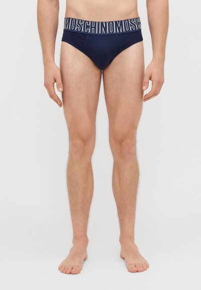 Slip da uomo blu navy con una banda logo bianca. Caratterizzati da una vestibilità aderente e un tessuto liscio. Senza fantasie o ulteriori accenti visibili.