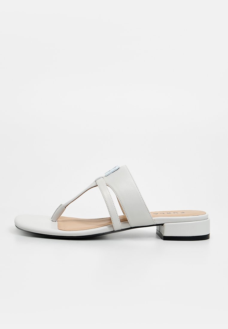 Sandalia plana blanca con diseño de tira en T, parte superior de cuero suave y un pequeño tacón cuadrado. Cuenta con dos tiras anchas horizontales para mayor soporte.