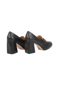 Scarpe con tacco alto in pelle nera, con punta quadrata, tacco largo prominente e un fiocco decorativo sulla parte anteriore. Texture liscia con una finitura lucida.