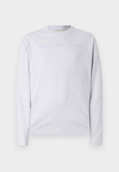Maglietta grigia chiara a maniche lunghe realizzata in cotone morbido, con scollo rotondo e delicato testo blu sulla parte anteriore.