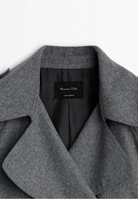 Col et revers de manteau en laine grise avec doublure intérieure noire et étiquette indiquant "Massimo Dutti Made in Morocco."