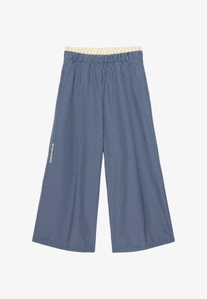Niebieskie spodnie o szerokich nogawkach w biały wzór w kratę i beżowa elastyczna talia, ułożone płasko na białym tle.
