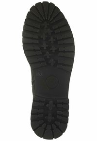 Suela de bota de goma negra con patrones de grabado profundos; presenta diseños en zigzag y cruz para tracción; emblema circular cerca del talón.