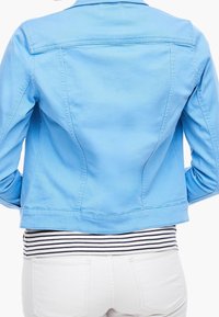 Helles blaues Jeansjackett mit taillierter Passform, sichtbaren Nähten und einer cropped Länge, kombiniert mit einem gestreiften Oberteil und weißen Jeans.