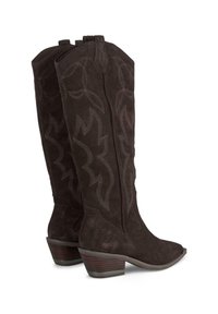 Brązowe zamszowe kowbojki z ostrymi czubkami i 2-calowym piętą w kształcie stosu. Wzdłuż boków mają dekoracyjne przeszycia w falistym wzorze.