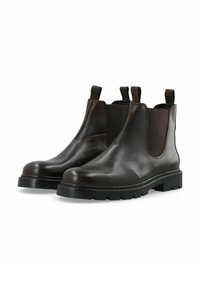 Botas Chelsea de cuero marrón con paneles laterales elásticos, punteras redondeadas y suelas de goma negra texturizada. Cuenta con tiradores para facilitar el uso.
