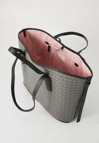 Gray patterned tote bag with black straps and a pink striped interior featuring a zip pocket and a label.