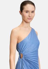 Niebieska sukienka na jedno ramię charakteryzuje się żebrową teksturą, skręconym detalem w talii z rozcięciem, tworząc dopasowaną sylwetkę.