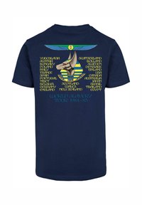 Marineblaue Baumwoll-T-Shirt mit einem grafischen Design einer hundeähnlichen Figur und Text, der Länder auflistet, mit "WELT-SKLAVEREI-TOUR 1984-85" am unteren Rand.