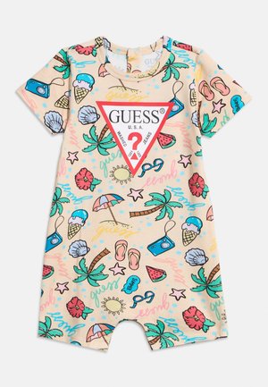 Combinaison courte à manches courtes pour tout-petit avec des imprimés colorés sur le thème de l'été, palmiers, glaces, appareils photo, et un grand triangle rouge avec le logo Guess sur le devant.