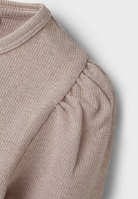 Helles rosa Rippoberteil mit hohem Kragen und gerafften Puffärmel-Details. Das Material hat eine subtile Schimmerstruktur.