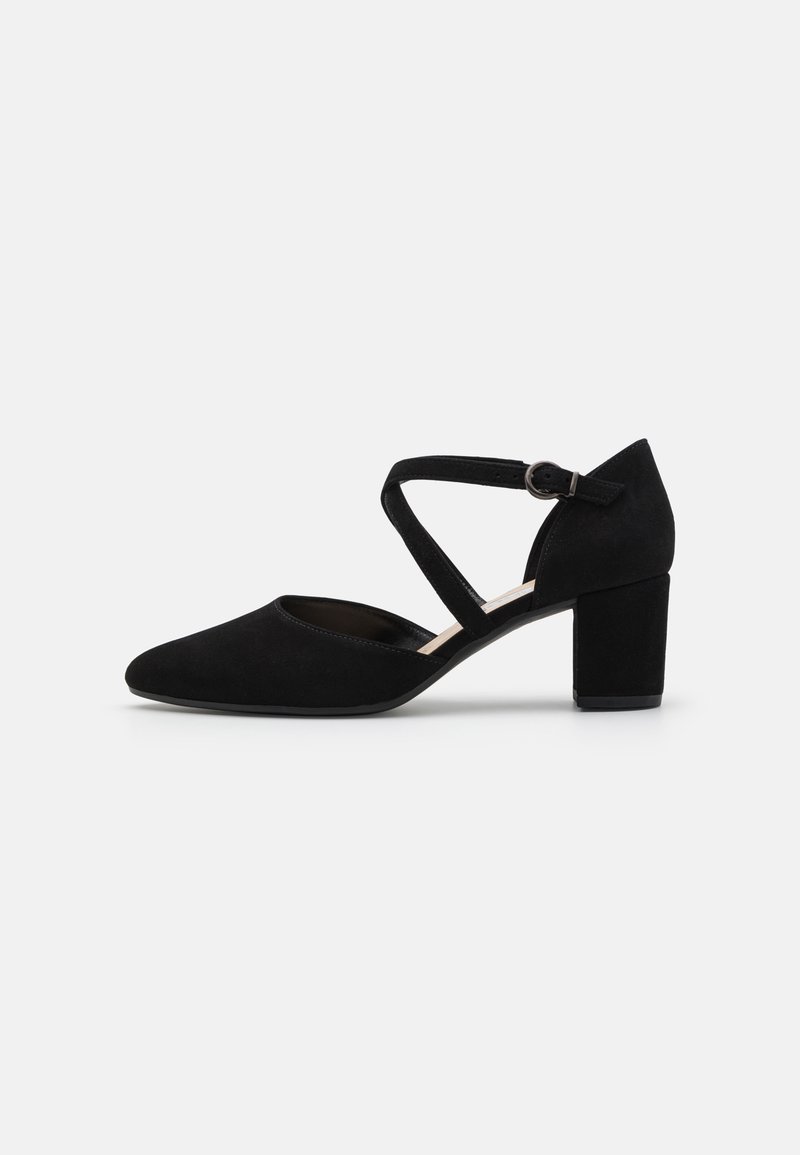 Chaussure à talon bas en daim noir avec bout pointu et bride de cheville croisée avec boucle sur fond blanc.