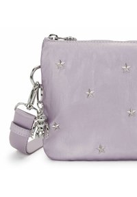 Borsa in tessuto viola con decorazioni a forma di stella argentata e un ciondolo a forma di scimmia metallica. Presenta una tracolla staccabile e una chiusura a zip.