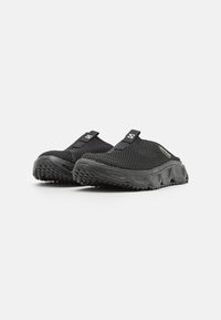 Pantofi negri tip slip-on, cu un superior din plasă, talpă texturată și bucle de prindere. Proiectați pentru confort, cu o talpă din cauciuc durabilă pentru aderență.