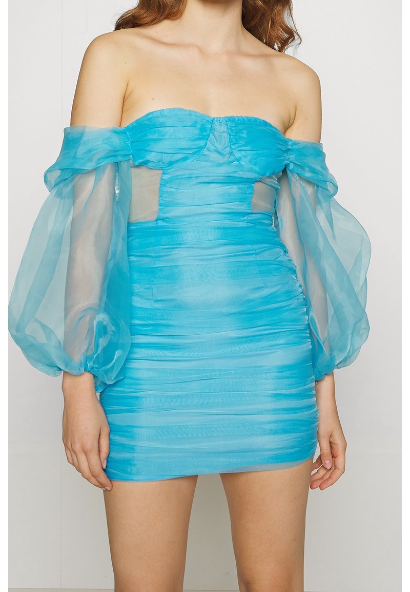 Bezramenné mini šaty v jasně tyrkysové barvě se sklady. Průhledné balónové rukávy a průsvitné síťové detaily vytvářejí vrstvený efekt.
