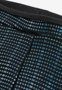 Schwarzer Stoff mit Pailletten in verschiedenen Blautönen, die in einem Gittermuster angeordnet sind. Glatte Textur, Nahaufnahme von Designdetails und Nähte.