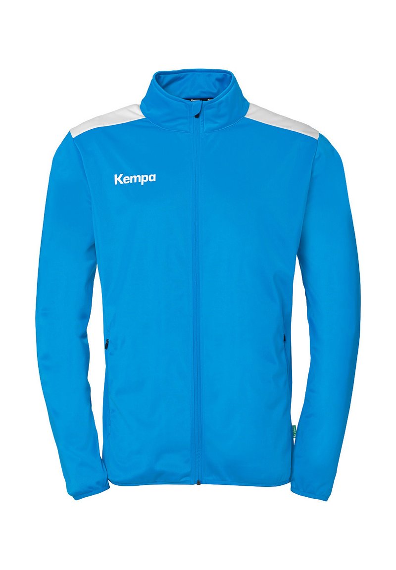 Blå sportsjakke med høj krave, hel lynlås, hvide skulderdetaljer og sidelommer. Der er brandnavnet "Kempa" på brystet.