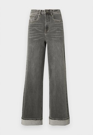 Harmaat leveälahkeiset farkut, joissa on korkea vyötärö, viisi taskua ja käännetyt lahkeet. Kangas on hieman kulunut ja siinä on näkyvät saumat.