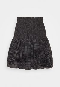 Jupe noire à pois fabriquée en tissu léger. Comprend une taille smockée, un ourlet volanté et des pois blancs dispersés.
