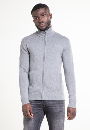 Jersey gris con cremallera, cuello alto, puños y dobladillo acanalados, y dos bolsillos laterales. Presenta un pequeño detalle de logo en el pecho.