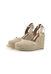 Espadrillas con zeppa beige, upper in tessuto trapuntato, piattaforma in juta intrecciata e cinturini alla caviglia legati con morbido tessuto. Punta tonda con dettagli cuciti.
