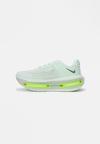 Adidași Nike de culoare verde deschis, cu un superior texturat, talpă albă și amortizare pe bază de aer vizibilă în talpă. Au șireturi și logo.