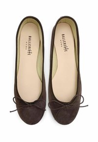 Bailarinas de ante marrón con punta redondeada, suave forro interior y detalle de lazo a juego en la parte frontal. Logo distintivo visible en el interior.