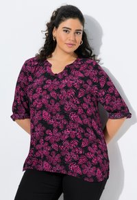 Czarna bluzka z różowym kwiatowym wzorem, z dekoltem w szpic, rękawami o długości trzech czwartek oraz marszczonymi dodatkami przy mankietach. Gładki, lekki materiał.