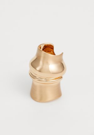 Inel tonifiat cu aur, cu un finisaj neted și strălucitor, având un design curbat și o bandă îngustă. Partea superioară are o formă neregulată cu un accent lucios.
