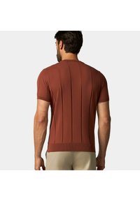 Pletený svetřík s krátkým rukávem v cihelnočervené barvě, se vertikálním žebrováním. Má kulatý výstřih a pevný spodní lem.