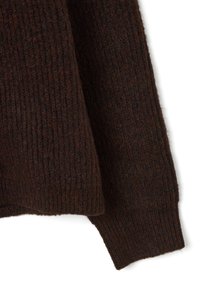 Tejido de suéter de punto marrón oscuro con textura acanalada. Presenta un dobladillo doblado y un material suave y grueso. Adecuado para superponer en climas más frescos.