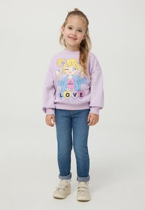 Felpa viola con design di cartone animato raffigurante una ragazza; con polsini e orlo a coste. Abbinata a jeans blu e sneaker bianche.