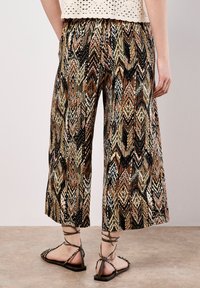 Mehrfarbige gemusterte Culottes in Schwarz, Braun und Creme mit weitem Bein. Verfügt über einen elastischen Bund und einen texturierten, leichten Stoff.